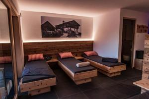 a room with two beds and two ottomans at Kieserhof Apartment Wald in Terento