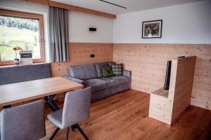 a living room with a couch and a table at Kieserhof Apartment Wald in Terento +23 photos