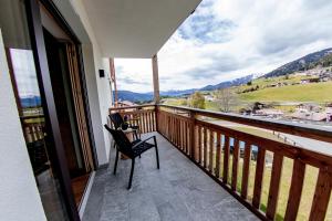 a balcony with a chair and a view of the mountains at Kieserhof Apartment Wald in Terento