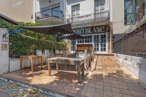 a patio with tables and chairs and an umbrella at Portblanc Front in Arenys de Mar