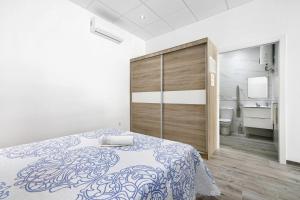 a bedroom with a bed and a large wooden cabinet at Apartamento Venus 2 in Conil de la Frontera