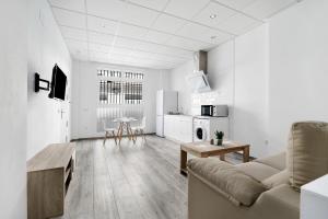 a white living room with a couch and a table at Apartamento Venus 2 in Conil de la Frontera