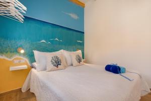 a bedroom with a white bed with a painting on the wall at Seguidilla Relax in Gran Tarajal +20 photos