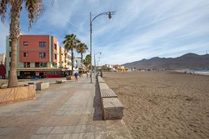 a street light on a sandy beach with palm trees at Seguidilla Relax in Gran Tarajal