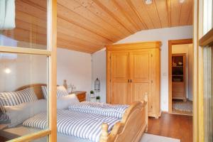 two beds in a bedroom with a wooden ceiling at Ferienwohnung Kramernest in Grainau