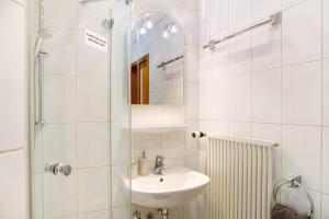 a white bathroom with a sink and a shower at Ferienwohnung Kramernest in Grainau +21 photos
