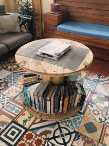 a coffee table with a pile of books on it at 1 River Central Hostel in Manila