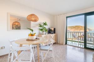 a dining room with a table and chairs and a balcony at Marsella in Port de Soller