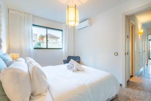 a bedroom with a white bed with two stuffed animals on it at Marsella in Port de Soller