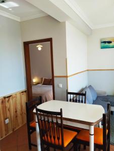 a dining room with a table and chairs and a bedroom at Casa Vale do Paraíso in Sesimbra