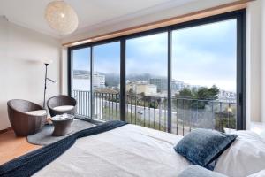 a bedroom with a bed and a large window at Casa Vale do Paraíso in Sesimbra