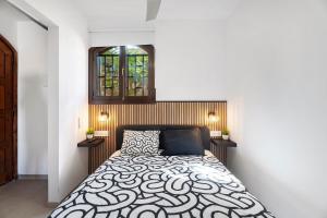 a bedroom with a bed with a black and white comforter at Casa Tagoro Dream in Costa Del Silencio +16 photos