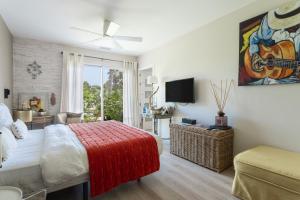 a bedroom with a large bed with a guitar painting on the wall at Lointaines escapades in Perpignan