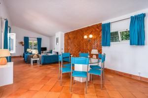 a living room with a table and blue chairs at Ocean Villa Algarve in Alvor