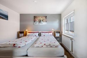 two twin beds in a room with two windows at Huus achtern Diek in Nordstrand