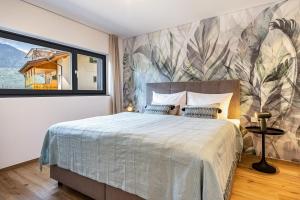 a bedroom with a large bed and a large window at Videre Lodge Wasserfall in Gargazzone