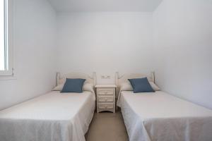 two beds sitting next to each other in a bedroom at Casa Robert in Conil de la Frontera +22 photos