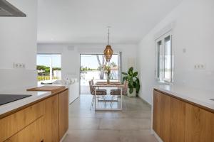 a kitchen with white walls and a table with chairs at Casa Robert in Conil de la Frontera