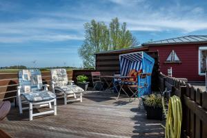a deck with chairs and a table and a fence at Huus achtern Diek in Nordstrand