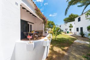 an external view of a house with a table and chairs at Cala Serena Beach 1 in Felanitx