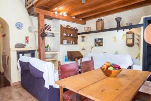 a dining room with a wooden table with a bowl of fruit on it at Cala Serena Beach 1 in Felanitx +16 photos