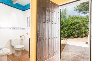 a bathroom with a toilet and a door at Cala Serena Beach 1 in Felanitx