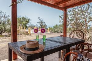 a table with a hat and flowers on a porch at Oasis en Cotillo in Roque +13 photos
