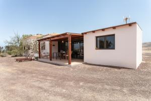 a small house in the middle of a field at Oasis en Cotillo in Roque