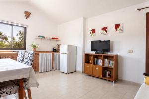 a living room with a refrigerator and a tv at Oasis en Cotillo in Roque