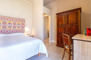 a bedroom with a bed and a wooden cabinet at Dimora Sella Rooms in Alghero +60 photos
