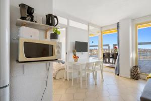 a kitchen with a table and a microwave at Salou apartment beach in Salou