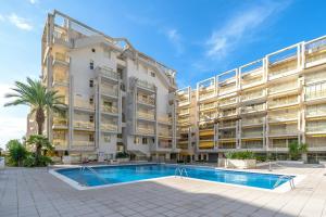 an apartment building with a swimming pool in front of it at Salou apartment beach in Salou