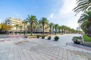 a street with palm trees and a building at Salou apartment beach in Salou