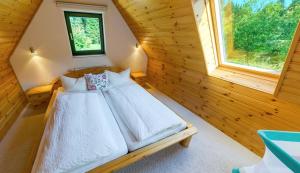 ein Schlafzimmer mit einem Bett in einem Blockhaus in der Unterkunft Ferienhotel Mühlleithen in Klingenthal