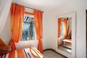 a bedroom with an orange curtain and a mirror at Finca Fani 1 in Agüimes +21 photos