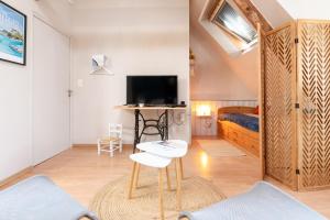 a room with a bed and a tv and a table at La Longère d'Arzoù Chambres D'hôtes in Baden