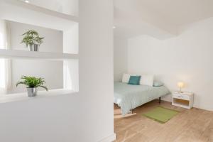a white room with a bed and a window at Piso Garaje Gratis Granada in Granada