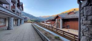 a walkway between buildings with mountains in the background at Appartement Valmeinier 1800 in Valmeinier +26 photos