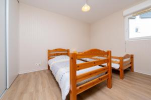 a bedroom with two bunk beds and a window at L'Optimist, parking, proche plages in Arzon