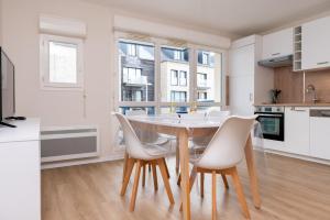 a kitchen and dining room with a table and chairs at L'Optimist, parking, proche plages in Arzon +14 photos