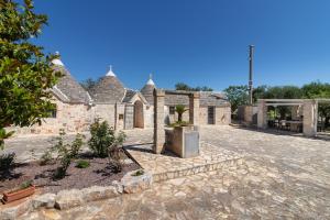 an old stone house with a courtyard in front of it at Trulli i Cedri, Monopoli in Monopoli