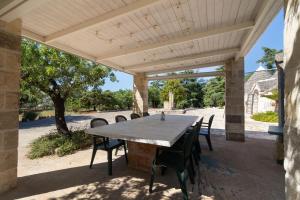 an outdoor table and chairs under a wooden pergola at Trulli i Cedri, Monopoli in Monopoli +27 photos