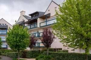 a building with trees in front of it at L'Optimist, parking, proche plages in Arzon