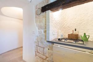a kitchen with a sink and a clock on the wall at Trulli i Cedri, Monopoli in Monopoli