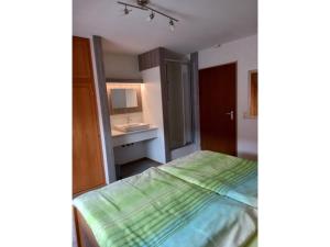 a small bedroom with a bed and a sink at Ferienwohnung Faller in Elzach