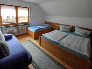 a small bedroom with two beds and a window at Ferienwohnung Faller in Elzach