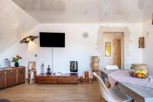 a living room with a table and a tv on the wall at fewo-wosink in Bad Krozingen
