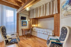 a bedroom with a bunk bed and two chairs at Petite Suite Douillette - Suite in Saint-Pargoire