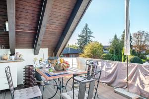 a patio with a table and chairs on a deck at fewo-wosink in Bad Krozingen