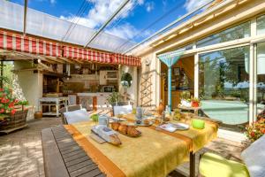 a dining room with a table and a large window at Petite Suite Douillette - Suite in Saint-Pargoire
